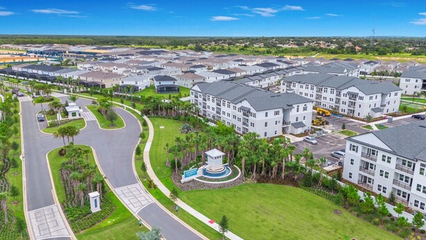A residential area with multiple two-story houses, a central circular driveway, and a small water feature. - Luxury Oasis Near Disney 6Brds ,with Private Pool (Clermont)