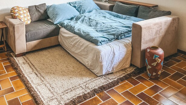 A cozy room with a sectional sofa, a painting on the wall, and a window with a view. - Gemütliche individuelle Wohnung oberhalb der Oker-Talsperre. (Schulenberg im Oberharz)