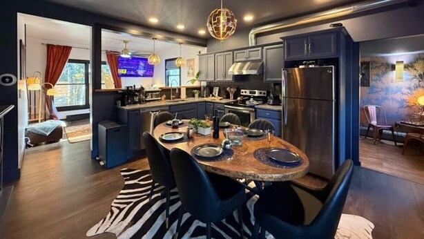 A modern kitchen with a central island, built-in appliances, and a dining area with a round table.