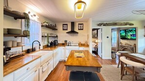 A modern kitchen with white cabinetry, a wooden island, and a built-in oven.