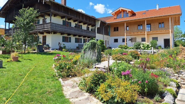 Un bâtiment à deux étages doté d’une façade en bois et d’un balcon.