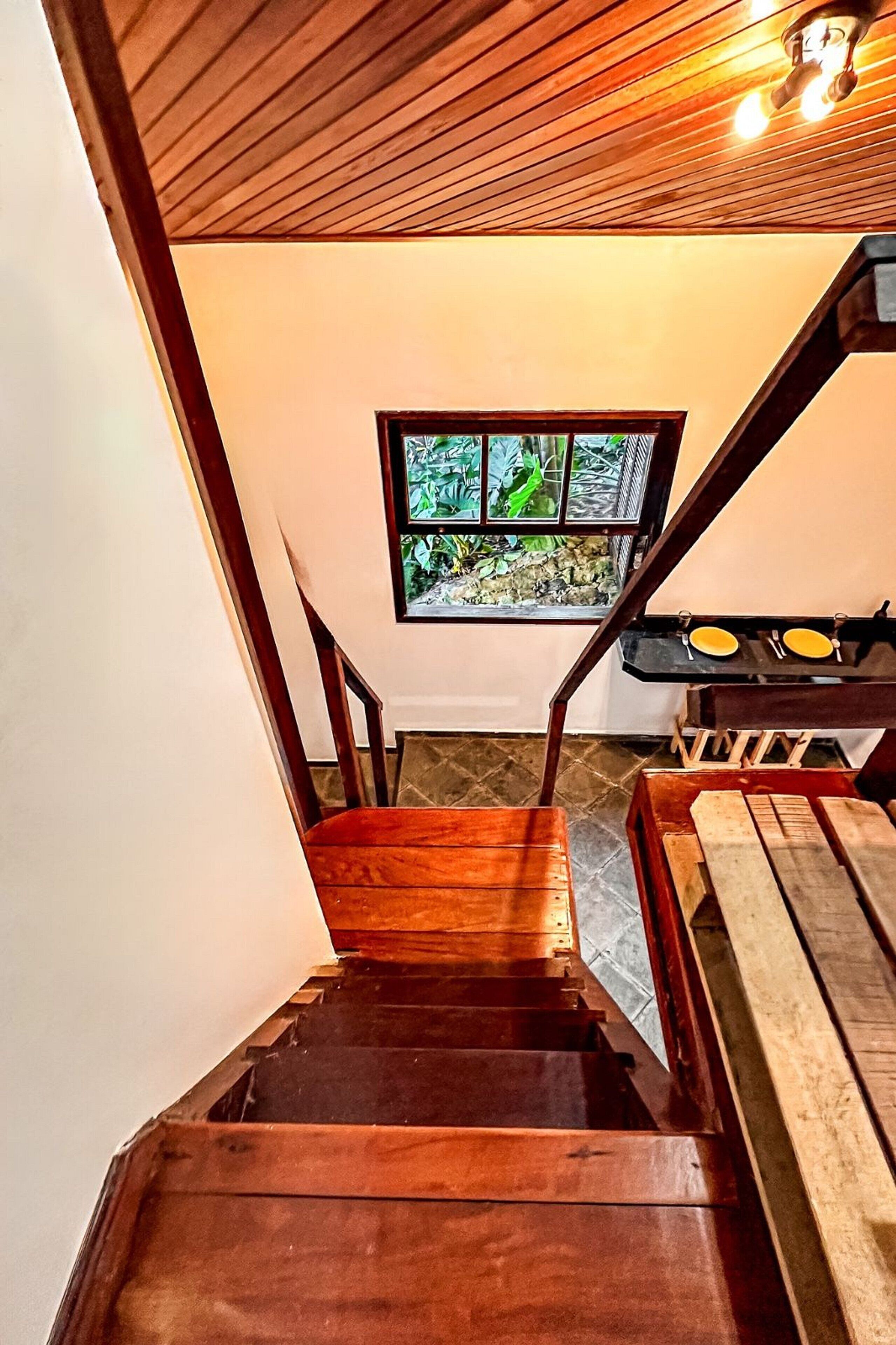 A wooden staircase leading to a room with a window.