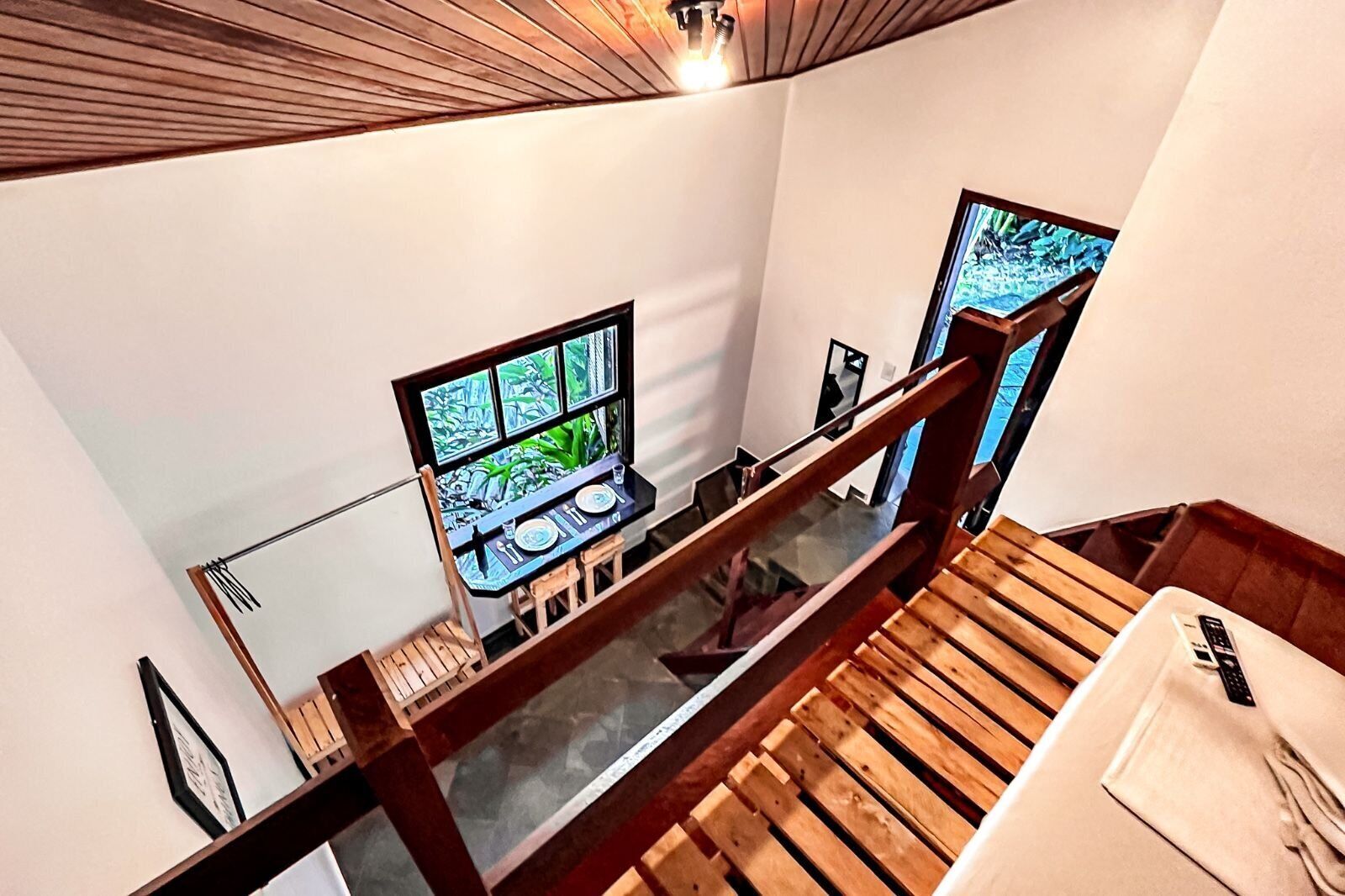 A staircase with wooden railings and a dining area with a table and chairs.