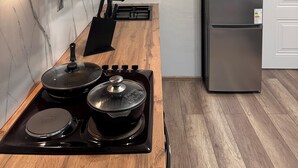 Una cocina con encimera de madera, estufa, refrigerador y una puerta blanca.