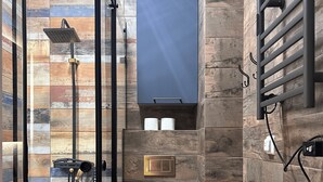 Un baño moderno con cabina de ducha, inodoro y perchero para toallas.