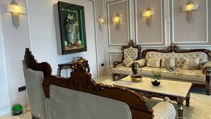 Un salon luxueux, avec un grand canapé, une table basse et un tableau décoratif au mur.