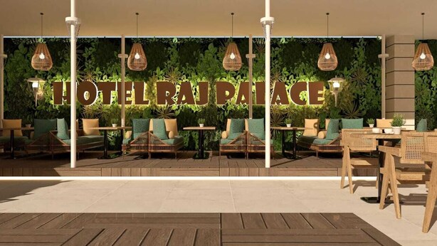 Un hall d’hôtel avec une grande enseigne indiquant « HÔTEL RA PAIA », des meubles en osier et des luminaires suspendus.