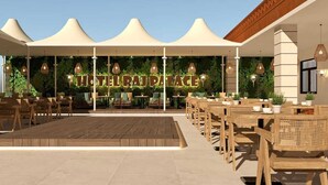 Une terrasse d’hôtel avec des sièges en plein air, une plateforme en bois et un auvent.