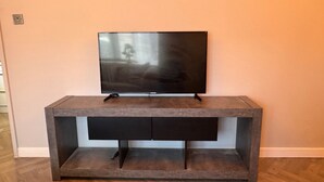 Moderni viihdekeskus, jossa on litteänäyttöinen televisio, sisäänrakennetut säilytystilat ja tyylikäs muotoilu.