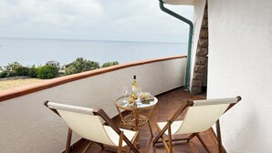 A balcony with a table, two chairs, a bottle, and glasses. - Villa Gabriella "Sea View" (Upper Floor Apartment) (Santa Maria del Mare)