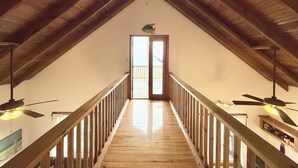 Un escalier en bois menant à un balcon d’où l’on peut admirer l’océan.