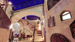 A cozy interior with a staircase, stone walls, and a blue railing. - Castle Inn Cave Cappadocia (Nevşehir)