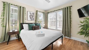 Ein Schlafzimmer mit Bett, Nachttisch und Deckenventilator.
