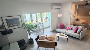 Ein modernes Wohnzimmer mit einer Couch, einem Holztisch und einem Essbereich mit Stühlen.