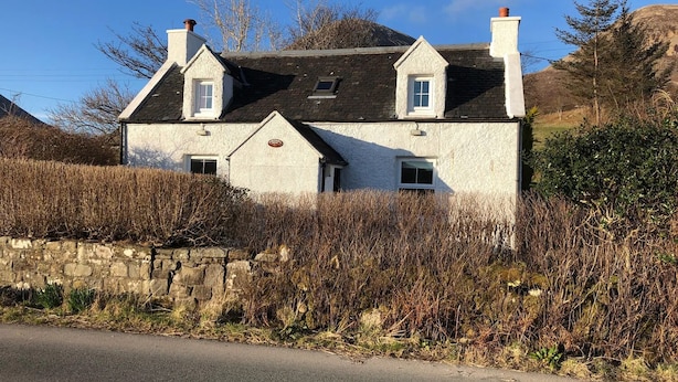 A white building with a stone wall in front, two chimneys, and a clear sky. - HAWTHORN DENE, pet friendly, cosy croft cottage with mountain views in Torrin (Torrin)