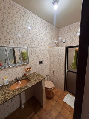 Een douche, handdoeken, zeep, toiletpapier
