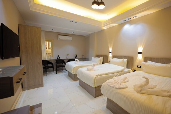 A hotel room with two beds, a desk, and a television. - Cairo Soul (Cairo)