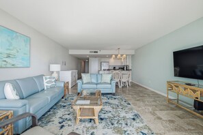 Un salon avec un canapé, une table basse et un téléviseur.