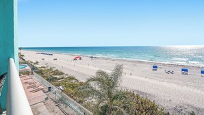 A beach view from a balcony with a pool, beach chairs, and umbrellas. - Gulf-Front Condo - Heated Pool - Sunset Views - Direct Beach Access - Sleeps 5 (Indian Shores)