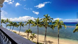 Blick auf einen Strand mit Palmen und blauem Himmel.