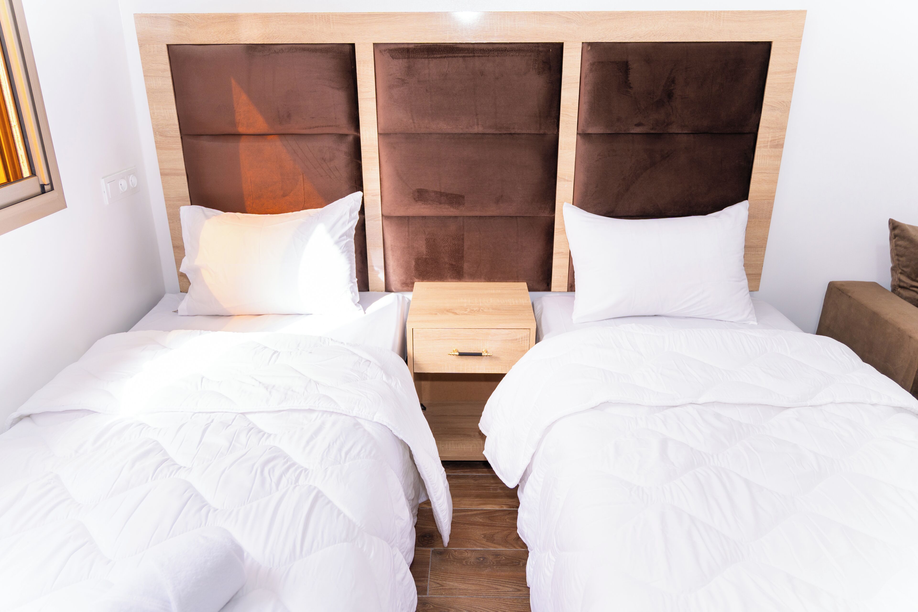 A double bed with a wooden headboard, a bedside table, and a nightstand.