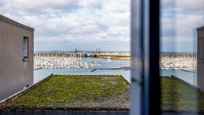 Een uitzicht op een jachthaven met aangemeerde boten, een brug op de achtergrond en gebouwen aan beide zijden.