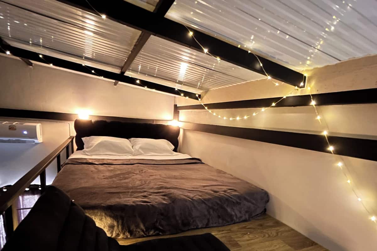A compact, modern bedroom with a bunk bed and a small desk area.