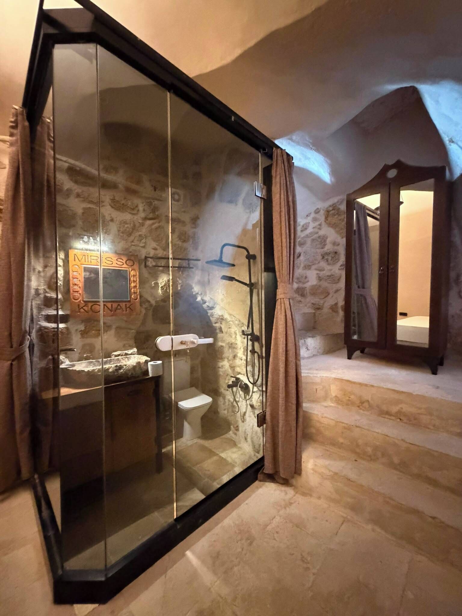 Un baño con ducha de vidrio, un lavabo y un inodoro.