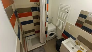 Chuveiro, secador de cabelo, toalhas de banho, papel higiênico