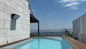 Ein Pool auf dem Dach mit freiem Blick auf den Himmel und ferne Berge.
