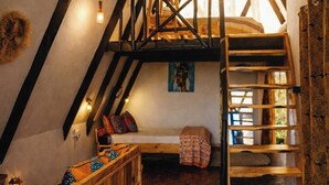 A cozy attic bedroom with a wooden bunk bed, a wooden bench, and a staircase. - leoglampingznz (Nungwi)