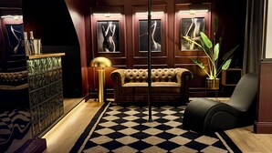 A luxurious room with a large, modern bathtub, a plush sofa, and a patterned rug. - Luxury Love Room (Grasse)