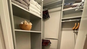Un armario compacto con estantes para ropa doblada, un mueble con cajones y espacio para colgar.