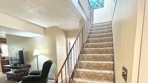 A carpeted staircase with a metal railing leading to a landing. - Emerald Escape - POOL! (Beckley)