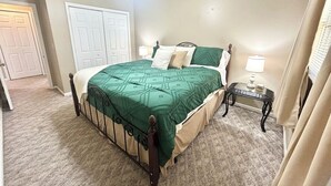 A bedroom with a bed, a nightstand, a ceiling fan, and a door. - Emerald Escape - POOL! (Beckley)