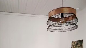 A room with a table and chairs, a tripod lamp, and a pendant light. - Furnished stopover (Belfort)