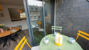 Un comedor con una mesa verde, sillas amarillas y una pared de vidrio.