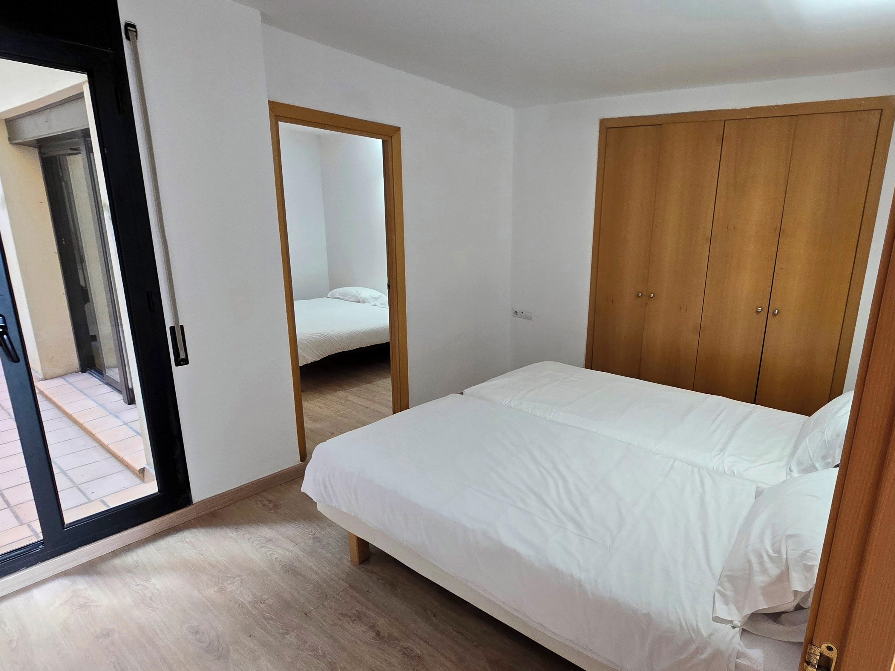 Un dormitorio con cama, armario y espejo.