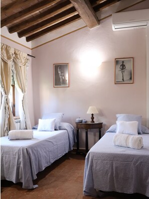 A room with two beds, a small table with a lamp, and two framed pictures on the wall. - Agriturismo Case Corboli Villetta Rufino (Todi)