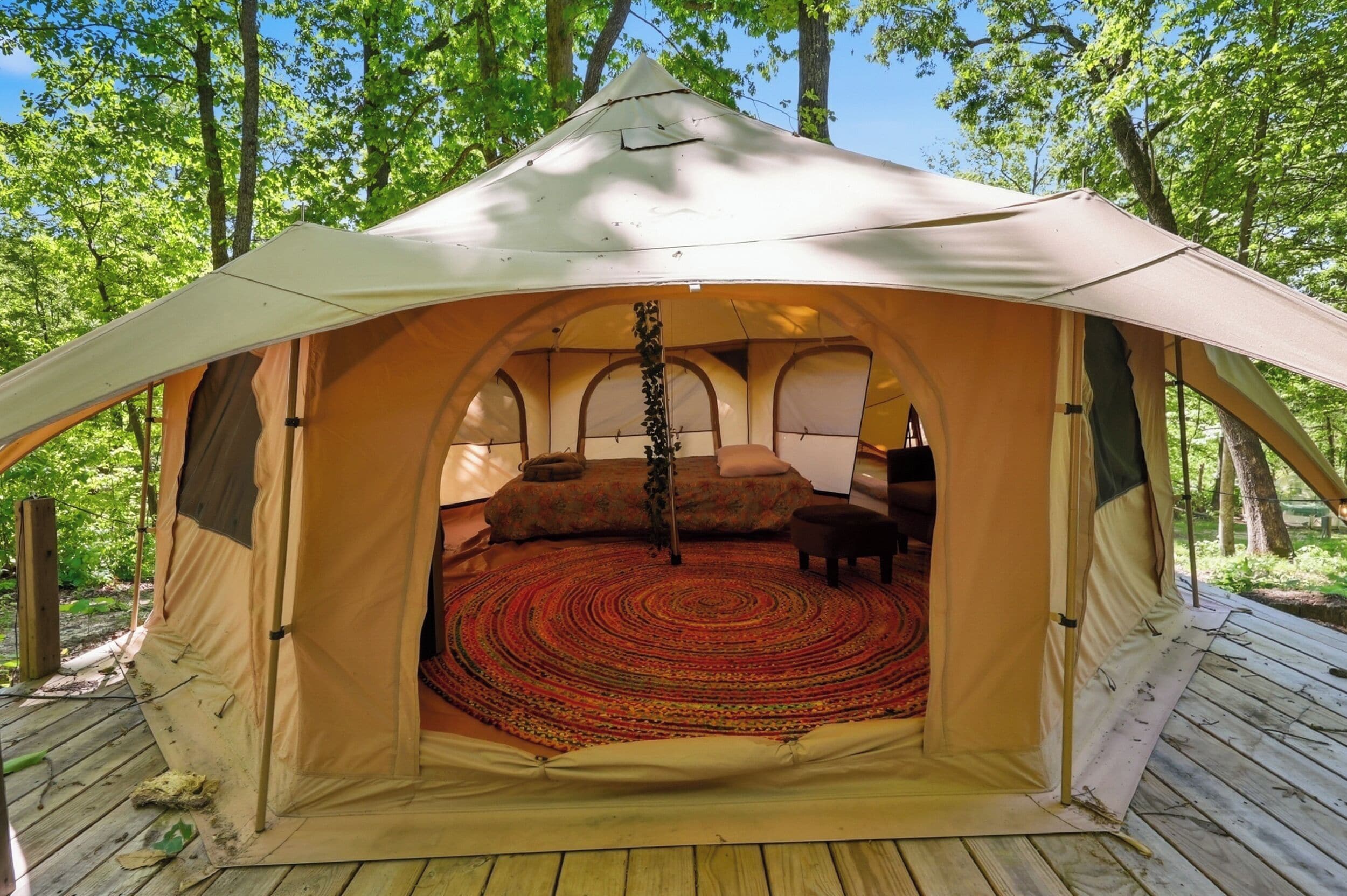 A tent with a circular interior, a central pole, and a patterned floor.