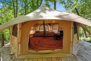 A tent with a circular interior, a central pole, and a patterned floor.