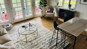 A living room with a sofa, a coffee table, a TV, and a dining area with a table and chairs.
