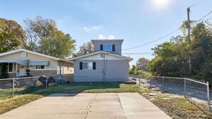A two-story house with a front yard, a fenced driveway, and a clear sky. - Enjoyable 3-bedroom house with AC in St. Louis (St. Louis)