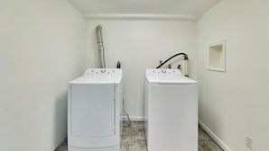 A laundry room with two white washing machines and a hose. - Enjoyable 3-bedroom house with AC in St. Louis (St. Louis)
