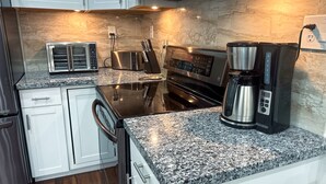 A modern kitchen with granite countertops, stainless steel appliances, and white cabinetry. - Enjoyable 3-bedroom house with Jacuzzi, Mini Golf and Cantal AC in Canyon Lake. (Canyon Lake)
