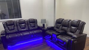 A room with a black leather sofa and a recliner with blue LED lighting. - Enjoyable 3-bedroom house with Jacuzzi, Mini Golf and Cantal AC in Canyon Lake. (Canyon Lake)