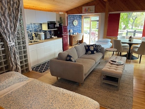 Una sala de estar moderna con sofá, reposapiés y zona de comedor.