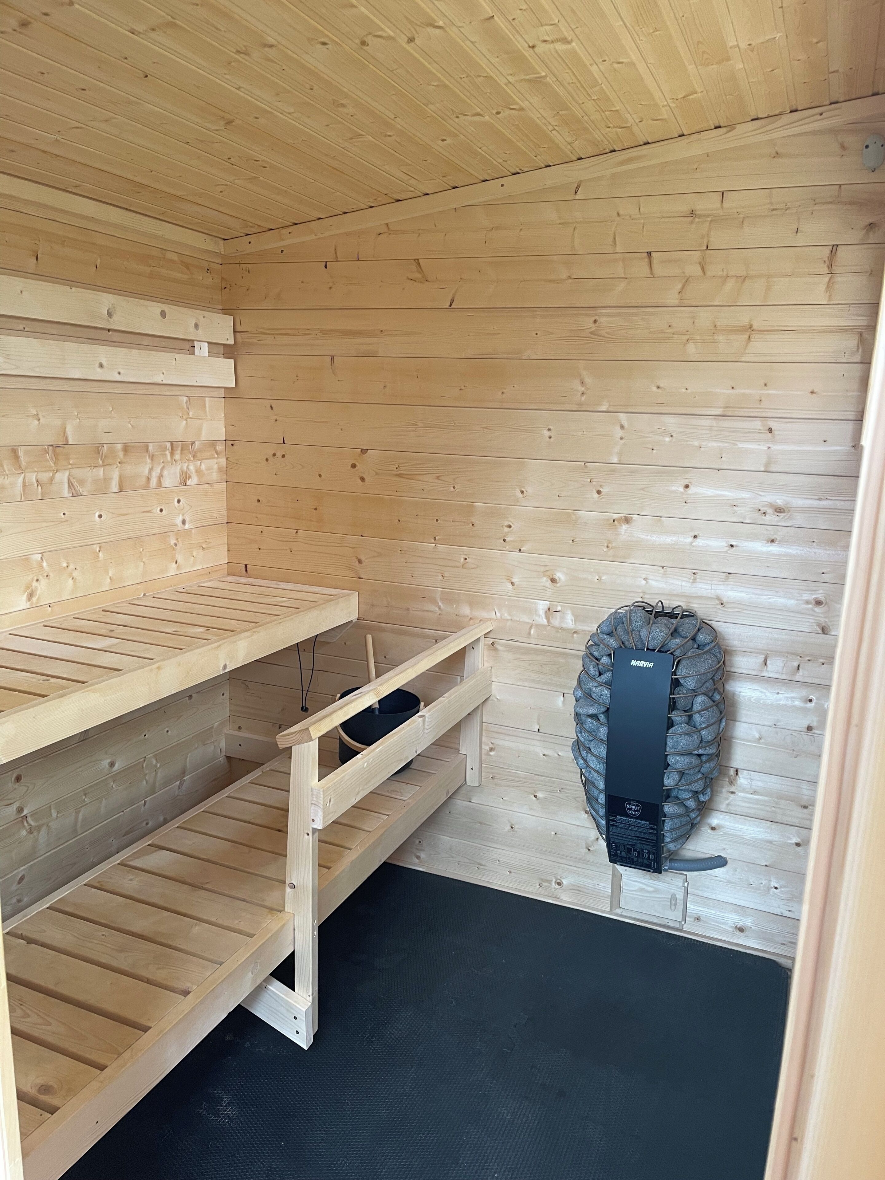 A sauna room with wooden walls and benches.