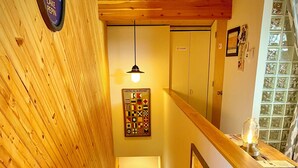 Una escalera de madera con barandilla, un letrero en la pared y una obra de arte con temática náutica.