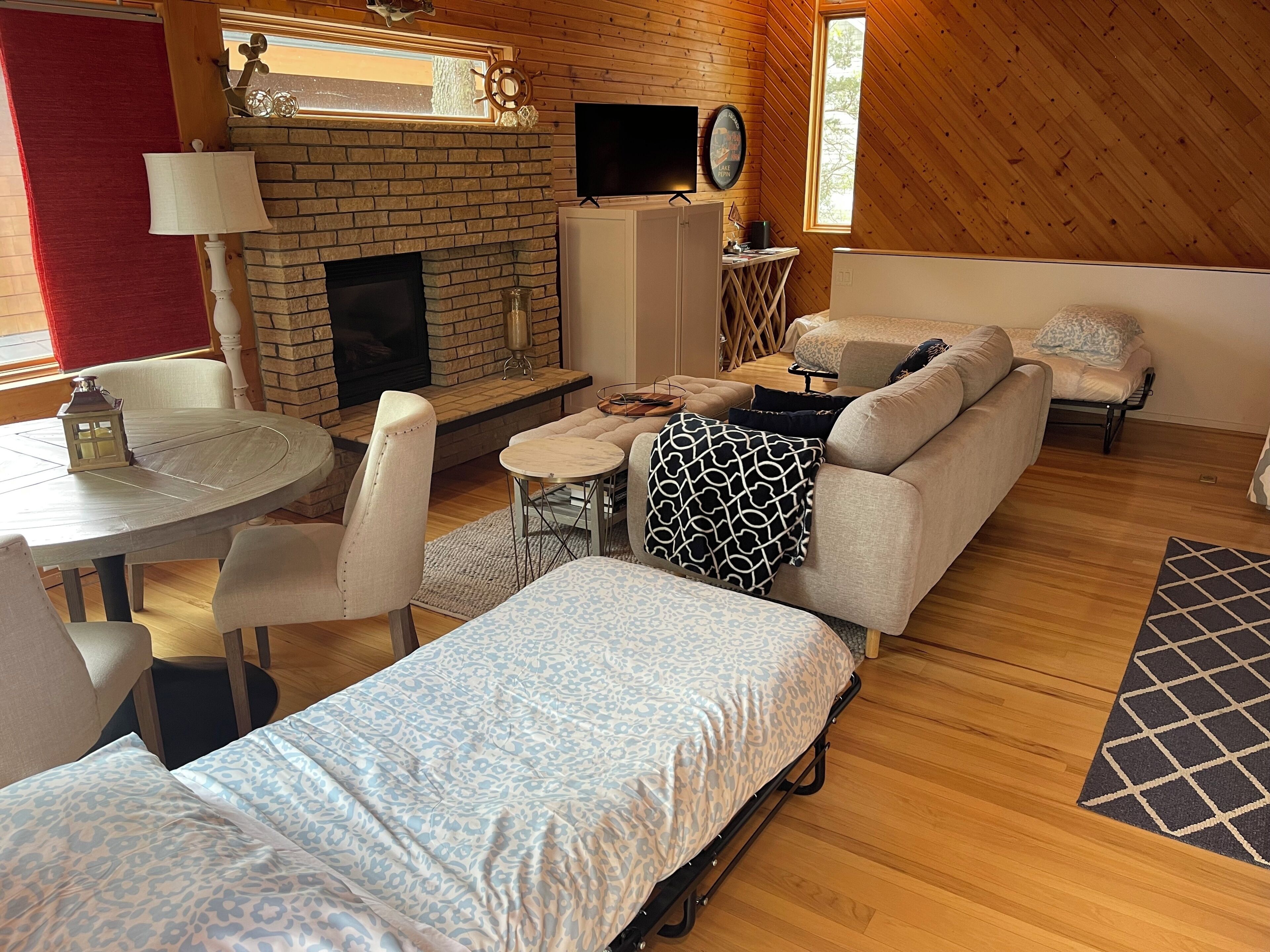 A cozy living room with a fireplace, a television, a sofa, and a dining table.